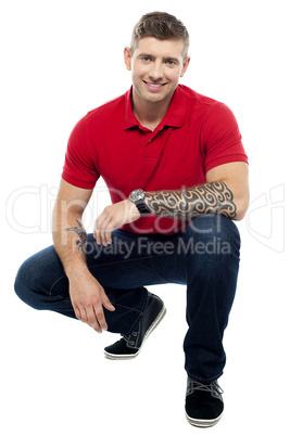 Young man sitting in squatting position