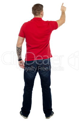 Back pose of man pointing at copy space area