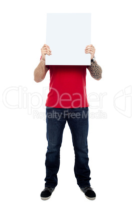 Man hiding his face behind blank white ad board