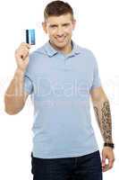 Trendy smart male showing credit card to camera