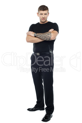 Bodyguard with tattoo. Posing with folded arms