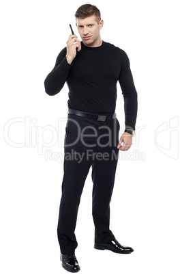 Bodyguard communicating via walkie-talkie