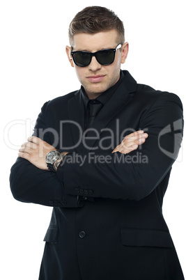 Young stylish bouncer in a black suit, arms folded