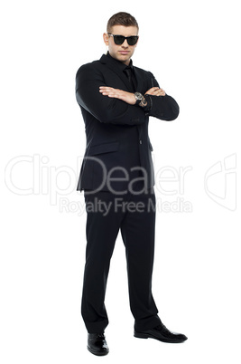 Young stylish bouncer in a black suit, arms folded