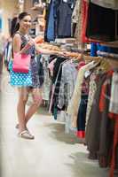 Woman standing at the clothes rack searching