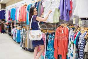 Woman  looking at price tag while holding clothes
