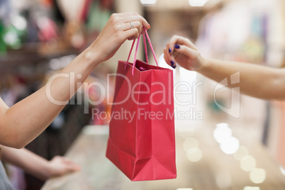 Woman handing over shopping bag