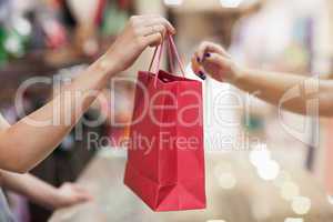 Woman handing over shopping bag