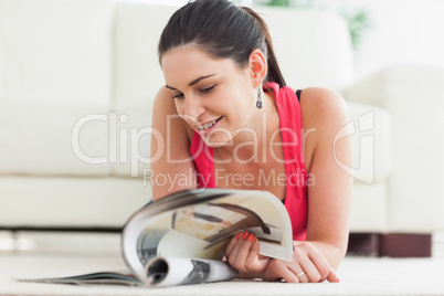Woman lying on floor looking at catalog