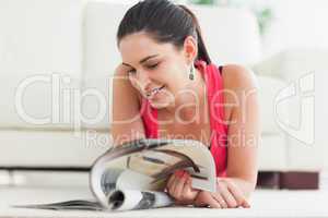 Woman lying on floor looking at catalog