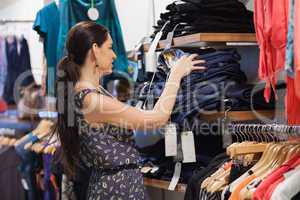 Woman stacking jeans on shelf