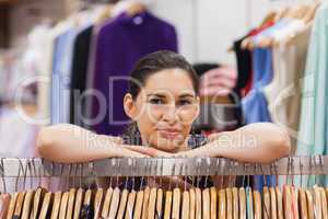 Woman leaning on clothes rack