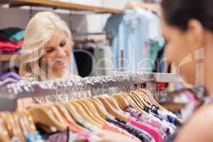 Woman looking at the clothes rack with friend