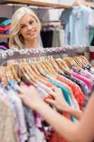 Woman standing at the clothes rack smiling