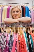 Woman lean on a clothes rack looking satisfied