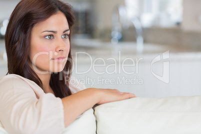 Woman on sofa looking thoughtful