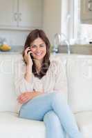 Woman phoning and sitting on the couch