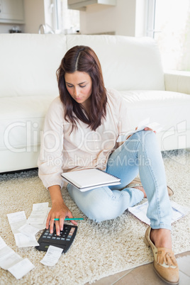 Woman sitting on the carpet checking bills