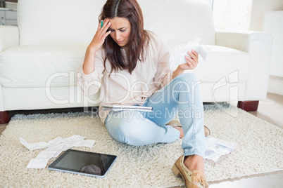 Woman with tablet pc calculating bills
