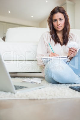 Woman writing on a paper while calculating