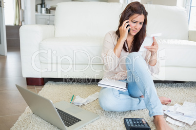 Woman calling and reading a bill