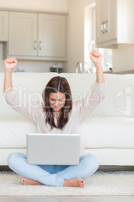 Woman celebrating in front of laptop