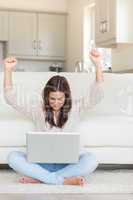 Woman celebrating in front of laptop