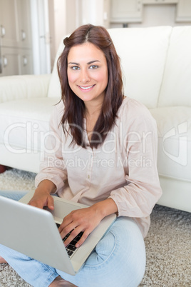 Brunette sitting on the floor with her laptop