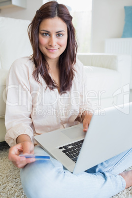 Woman holding a credit card and a laptop