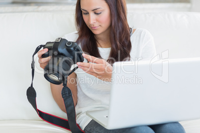 Woman holding a laptop and a camera