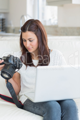 Woman viewing photos while holding a laptop