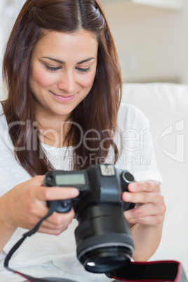 Brunette viewing photos while sitting on the sofa