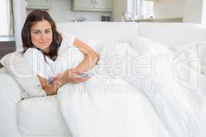 Woman relaxing on the sofa and holding a remote