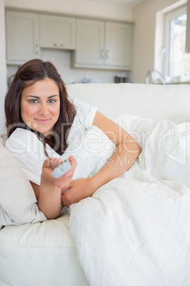Woman smiling and holding a remote