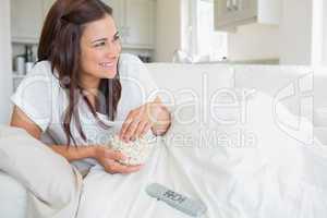 Woman eating popcorn while watching television