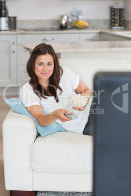 Woman watching television and smiling