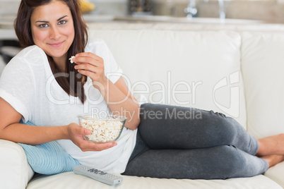 Woman eating popcorn and smiling