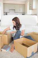Woman happily unpacking moving boxes