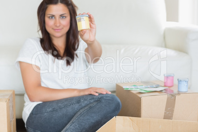 Smiling woman presenting yellow paint