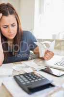 Brunette looking worried and holding bills