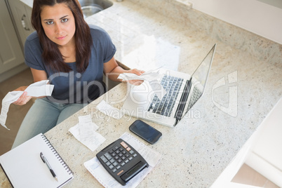 Young woman calculating bills and looking worried