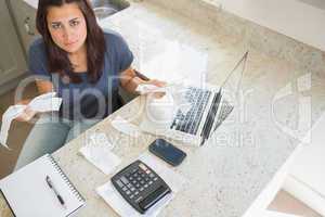 Young woman calculating bills and looking worried