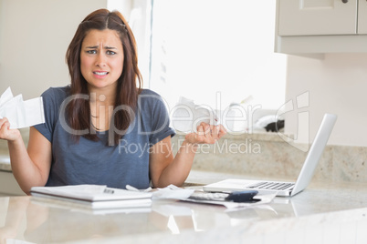 Woman looking troubled while holding bills