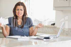 Woman looking troubled while holding bills