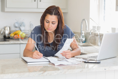 Woman calculating receipts with laptop