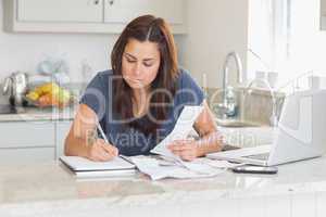 Woman calculating receipts with laptop