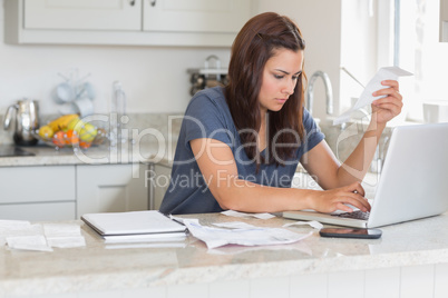 Woman holding a bill while calculating