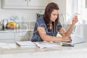 Woman holding a bill while calculating