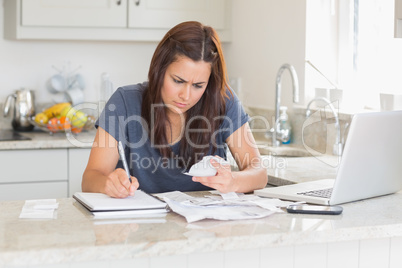 Woman calculating bills in the kitchen