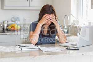 Stressed woman looking down at bills